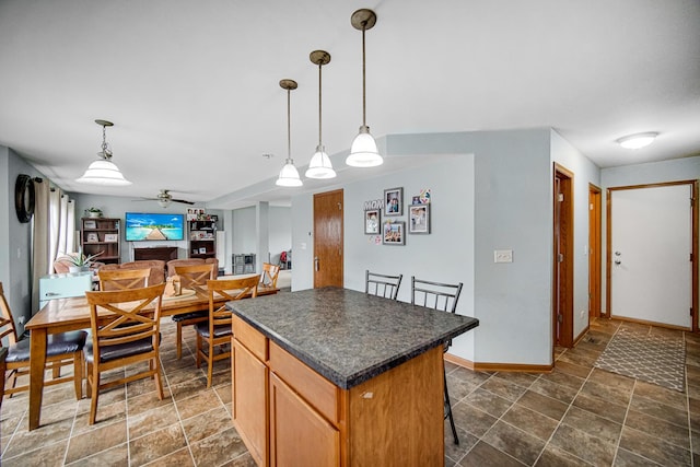 8304 Trumbull Ave, Joliet, IL 60431 - kitchen with dark countertops, a kitchen island, a ceiling fan, and stone finish flooring