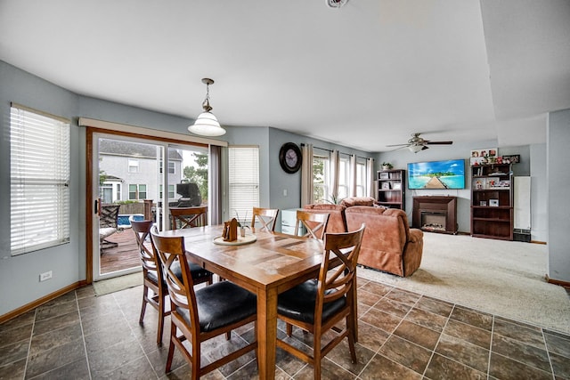 8304 Trumbull Ave, Joliet, IL 60431 - dining area with a fireplace, ceiling fan, and dark stone finish floors