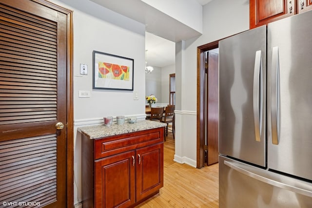 4503 N Ashland Ave Unit 2N, Chicago, IL 60640 - kitchen featuring freestanding refrigerator, light wood-style flooring, light stone countertops, and a chandelier