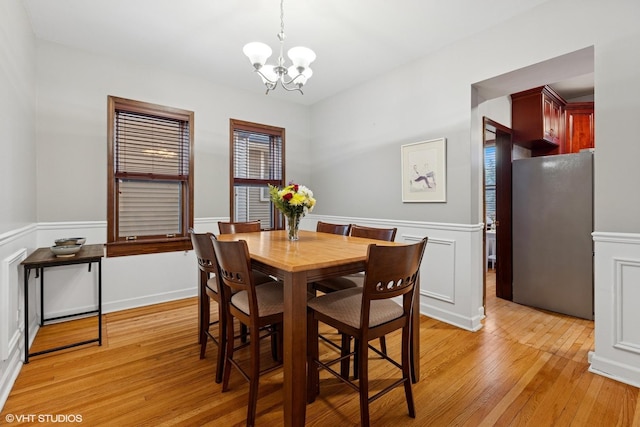 4503 N Ashland Ave Unit 2N, Chicago, IL 60640 - dining room with a chandelier, light wood finished floors, and wainscoting