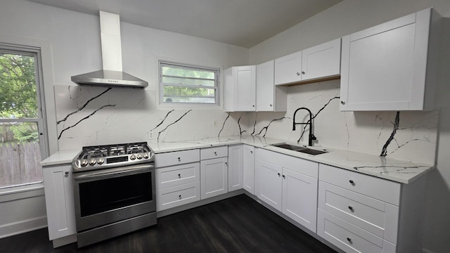 208 N Chestnut St, Aurora, IL 60506 - kitchen with stainless steel gas stove, wall chimney range hood, plenty of natural light, and white cabinetry