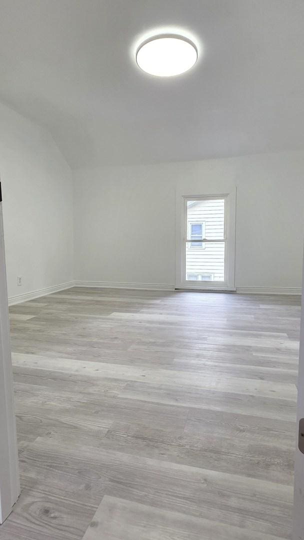 208 N Chestnut St, Aurora, IL 60506 - unfurnished room featuring light wood-type flooring and vaulted ceiling
