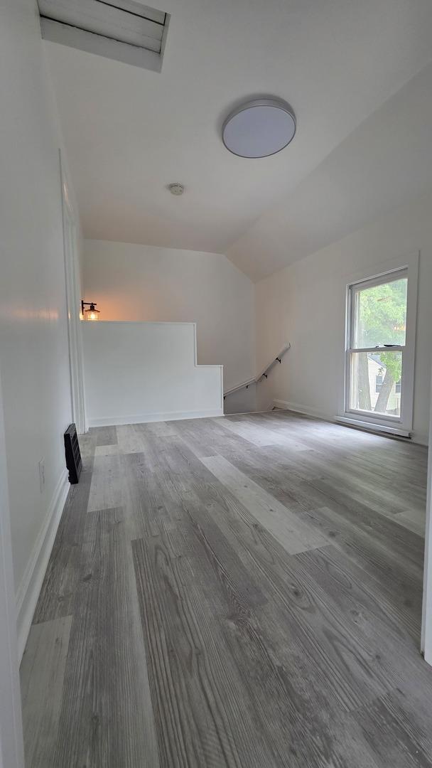 208 N Chestnut St, Aurora, IL 60506 - empty room with lofted ceiling and wood finished floors