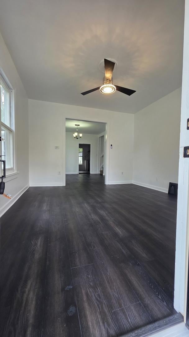 208 N Chestnut St, Aurora, IL 60506 - unfurnished living room with dark wood finished floors, ceiling fan, a chandelier, and healthy amount of natural light