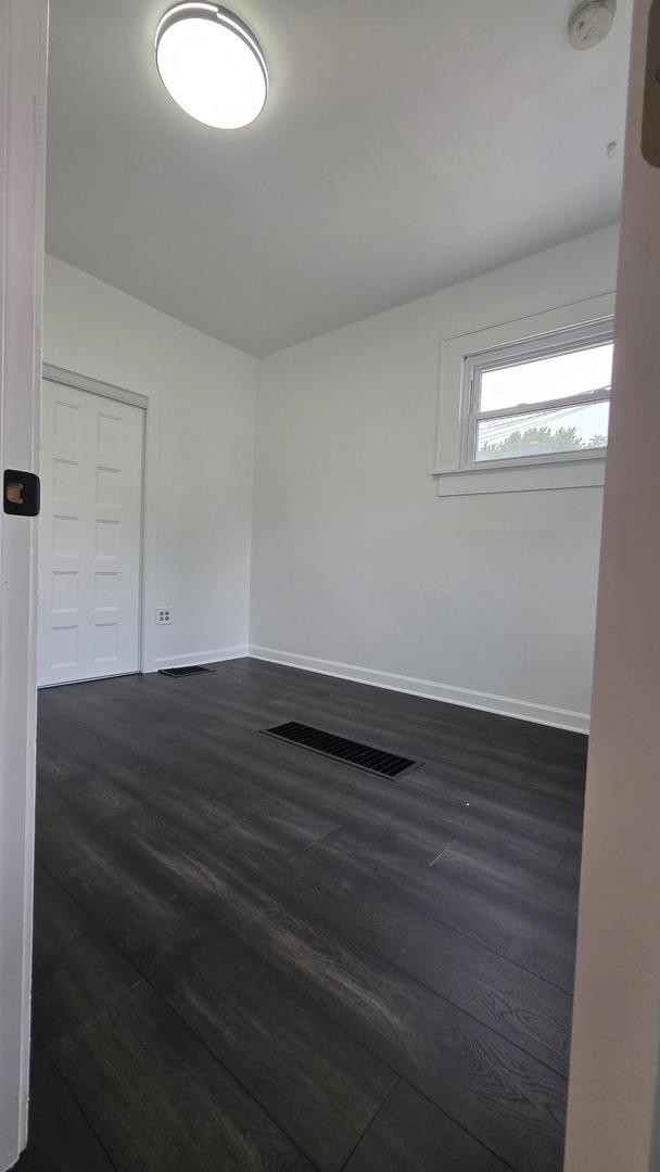 208 N Chestnut St, Aurora, IL 60506 - spare room with dark wood-style floors and baseboards