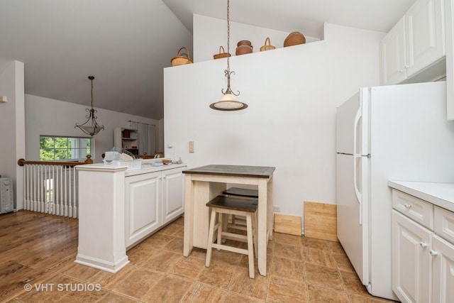 601 Cary Woods Cir Unit 601, Cary, IL 60013 - kitchen featuring lofted ceiling, freestanding refrigerator, white cabinets, a kitchen breakfast bar, and light countertops