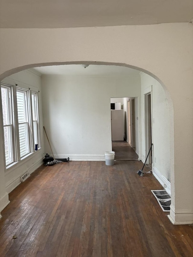 5604 S Morgan St, Chicago, IL 60621 - spare room featuring arched walkways and dark wood-type flooring
