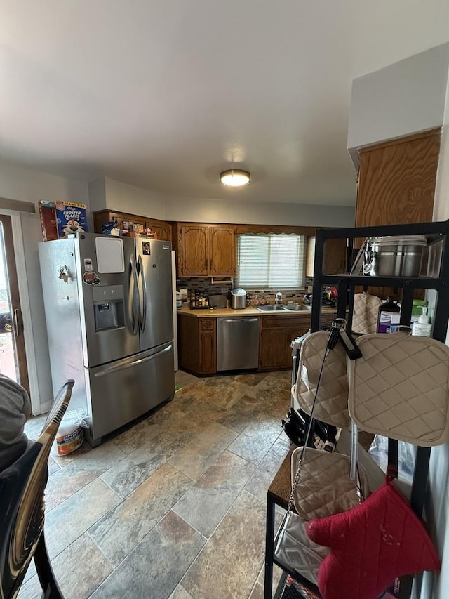 1208 E 154th St, South Holland, IL 60473 - kitchen with appliances with stainless steel finishes, stone tile flooring, brown cabinetry, backsplash, and light countertops