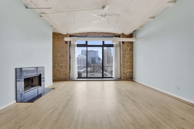 1322 S Wabash Ave Unit 807, Chicago, IL 60605 - unfurnished living room with wood finished floors, a ceiling fan, a fireplace, a skyline view, and brick wall