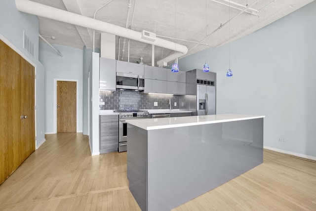 1322 S Wabash Ave Unit 807, Chicago, IL 60605 - kitchen featuring appliances with stainless steel finishes, modern cabinets, light wood finished floors, decorative backsplash, and light countertops