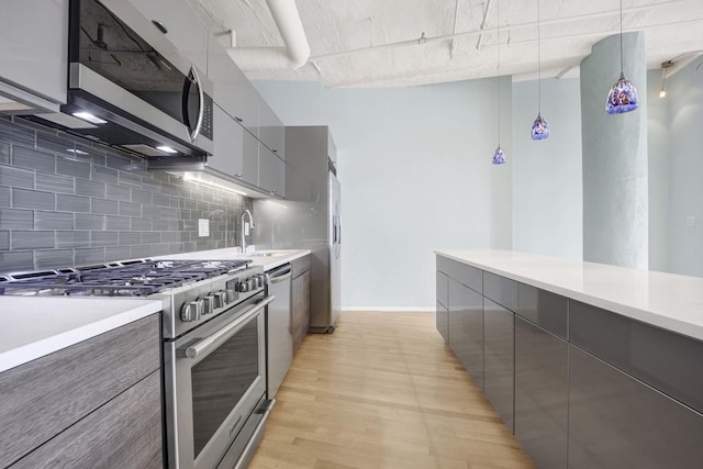 1322 S Wabash Ave Unit 807, Chicago, IL 60605 - kitchen with appliances with stainless steel finishes, gray cabinetry, modern cabinets, tasteful backsplash, and light wood-type flooring