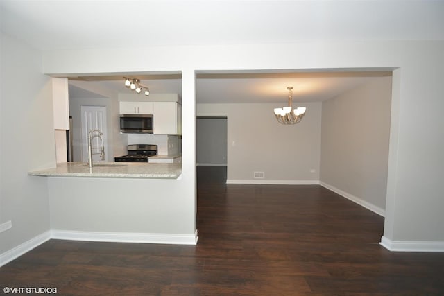 816 Blackhawk Dr, University Park, IL 60484 - kitchen with stainless steel appliances, a chandelier, white cabinets, decorative backsplash, and dark wood-style floors