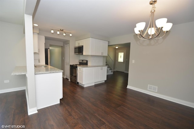 816 Blackhawk Dr, University Park, IL 60484 - kitchen featuring range with gas stovetop, stainless steel microwave, a chandelier, white cabinetry, and light stone countertops