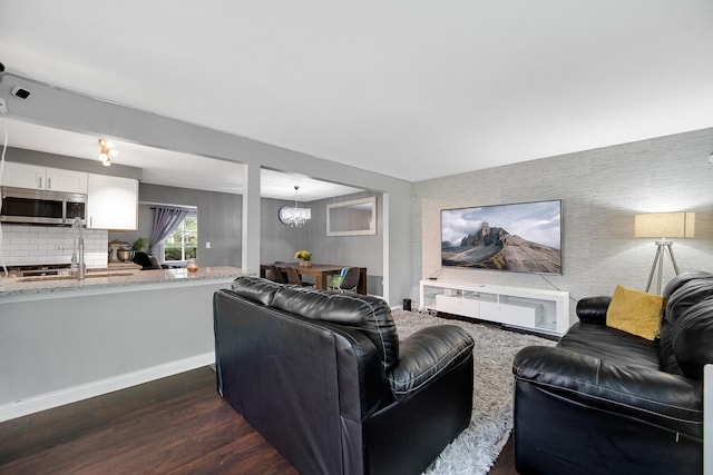 816 Blackhawk Dr, University Park, IL 60484 - living area featuring dark wood-style floors, a chandelier, an accent wall, and wallpapered walls