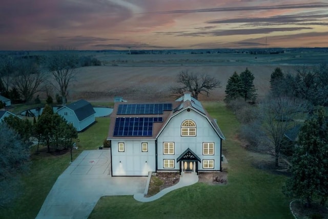 9439 Corneils Rd, Bristol, IL 60512 - view of front of property with concrete driveway, solar panels, a yard, and a chimney