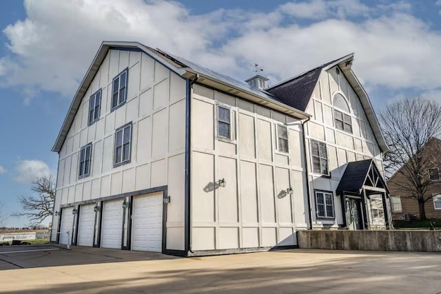 9439 Corneils Rd, Bristol, IL 60512 - view of side of home featuring an attached garage, board and batten siding, and driveway