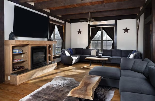 9439 Corneils Rd, Bristol, IL 60512 - living area with a wood ceiling with exposed beams, plenty of natural light, wood-type flooring, ceiling fan, and a glass covered fireplace