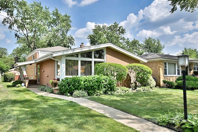 9353 Ewing Ave, Evanston, IL 60203 - view of front facade with brick siding, a front lawn, and a chimney