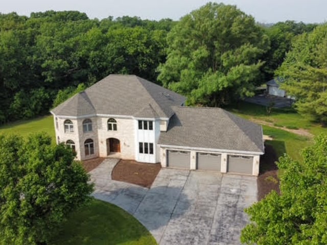 501 Bryan Trl, New Lenox, IL 60451 - view of front of house featuring an attached garage, concrete driveway, and a wooded view