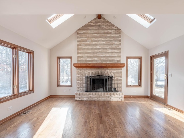 501 Bryan Trl, New Lenox, IL 60451 - unfurnished living room featuring a skylight, lofted ceiling, wood finished floors, and a fireplace