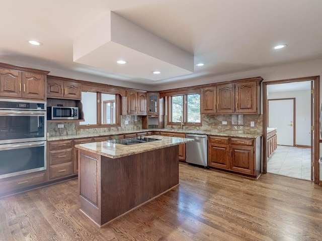 501 Bryan Trl, New Lenox, IL 60451 - kitchen featuring stainless steel appliances, backsplash, recessed lighting, wood finished floors, and light stone counters