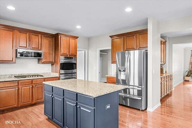 13311 Morning Mist Pl, Plainfield, IL 60585 - kitchen featuring stainless steel appliances, light wood finished floors, a center island, brown cabinets, and recessed lighting