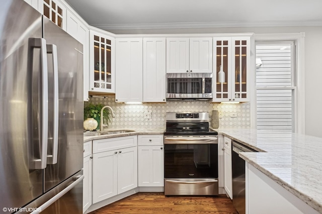 4848 N Seeley Ave, Chicago, IL 60625 - kitchen featuring appliances with stainless steel finishes, white cabinetry, crown molding, decorative backsplash, and light stone countertops