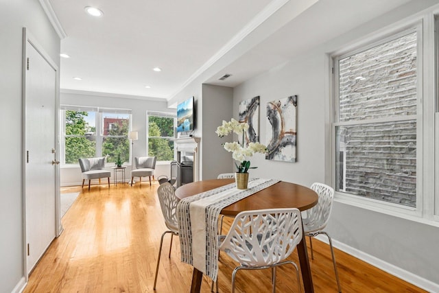 3522 N Fremont St Unit 2, Chicago, IL 60657 - dining space featuring light wood finished floors, a fireplace, crown molding, and recessed lighting