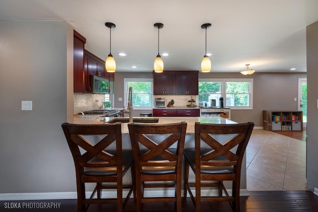 106 Grand Central Ln, Schaumburg, IL 60193 - kitchen featuring stainless steel microwave, decorative backsplash, healthy amount of natural light, a peninsula, and recessed lighting
