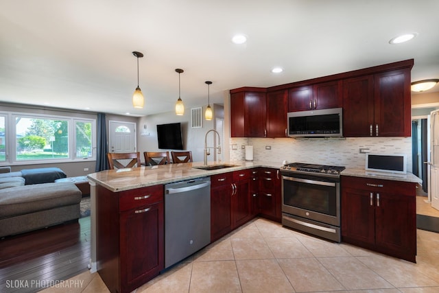 106 Grand Central Ln, Schaumburg, IL 60193 - kitchen with stainless steel appliances, open floor plan, a peninsula, dark brown cabinets, and recessed lighting