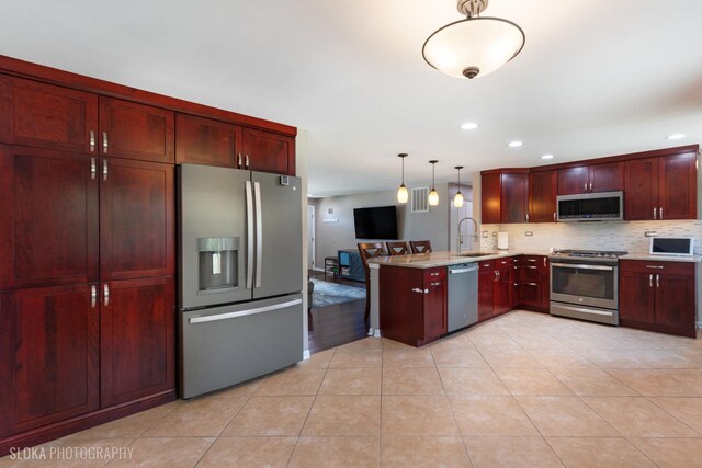 106 Grand Central Ln, Schaumburg, IL 60193 - kitchen featuring appliances with stainless steel finishes, dark brown cabinets, a peninsula, backsplash, and recessed lighting