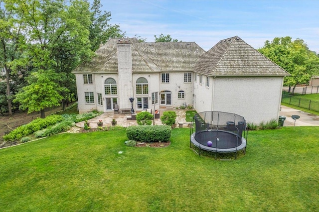 14695 Fox Hollow Ln, Lemont, IL 60439 - rear view of property featuring a trampoline, a patio area, a chimney, and stucco siding