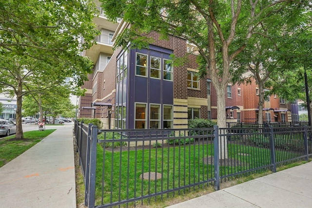 1159 N Hudson St Unit 1-101, Chicago, IL 60610 - view of front of house featuring brick siding, a fenced front yard, and a residential view