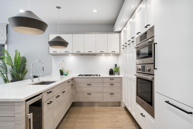 927 N Damen Ave Unit 2, Chicago, IL 60622 - kitchen featuring beverage cooler, a peninsula, light countertops, light wood-style flooring, and backsplash