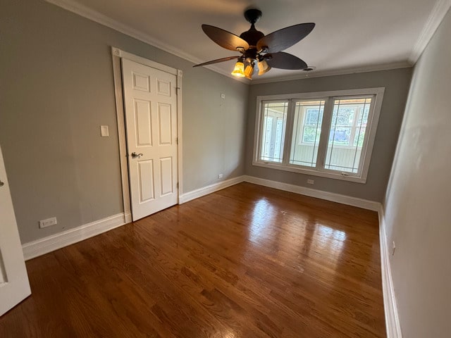2705 W 98th St, Evergreen Park, IL 60805 - spare room with crown molding, wood finished floors, and a ceiling fan