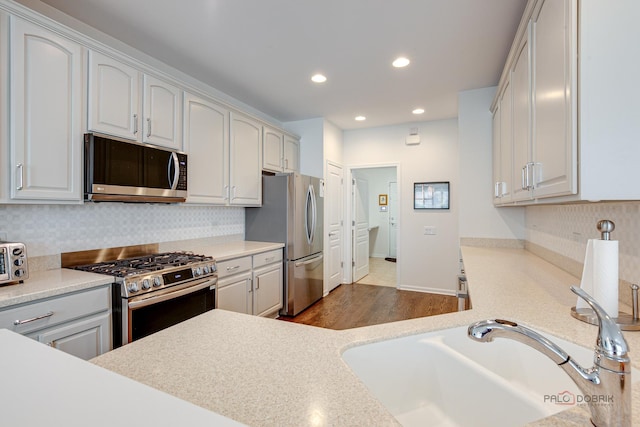 3181 Rockwell Cir, Mundelein, IL 60060 - kitchen featuring stainless steel appliances, recessed lighting, backsplash, light countertops, and wood finished floors