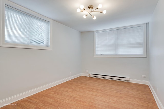 2624 W Catalpa Ave Unit 14, Chicago, IL 60625 - spare room featuring a baseboard radiator, a chandelier, and light wood finished floors