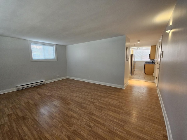 2624 W Catalpa Ave Unit 14, Chicago, IL 60625 - spare room featuring a baseboard heating unit, light wood-style flooring, and plenty of natural light