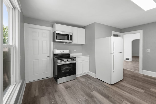 3225 Gilead Ave, Zion, IL 60099 - kitchen featuring appliances with stainless steel finishes, wood finished floors, white cabinets, arched walkways, and light countertops