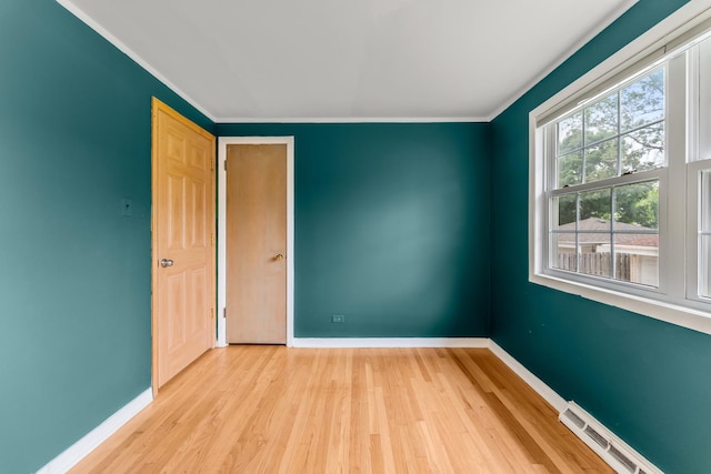 7446 Lake St, Morton Grove, IL 60053 - empty room featuring a baseboard heating unit, wood finished floors, and crown molding