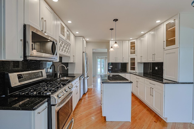 1831 E Camp Mcdonald Rd Unit 0, Mount Prospect, IL 60056 - kitchen featuring appliances with stainless steel finishes, light wood-type flooring, white cabinetry, a kitchen island, and backsplash