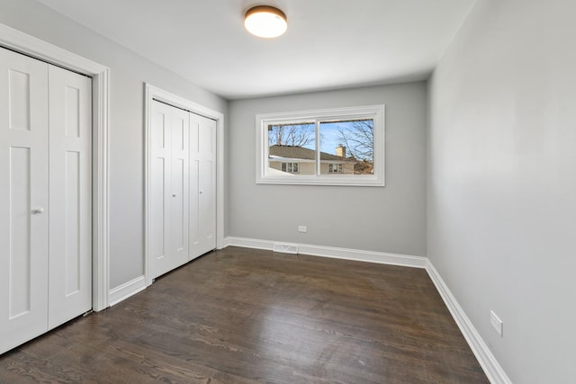 15245 Narcissus Ct, Orland Park, IL 60462 - unfurnished bedroom featuring dark wood-style flooring and two closets