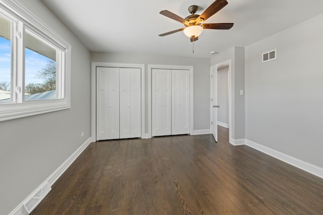 15245 Narcissus Ct, Orland Park, IL 60462 - unfurnished bedroom with multiple closets, dark wood-type flooring, and ceiling fan