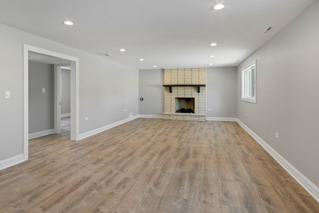 15245 Narcissus Ct, Orland Park, IL 60462 - unfurnished living room with recessed lighting, light wood-style flooring, and a brick fireplace