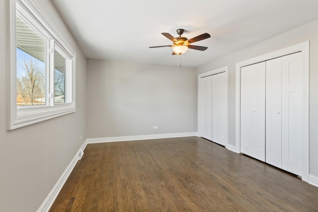 15245 Narcissus Ct, Orland Park, IL 60462 - unfurnished bedroom with multiple closets, dark wood-style flooring, and a ceiling fan