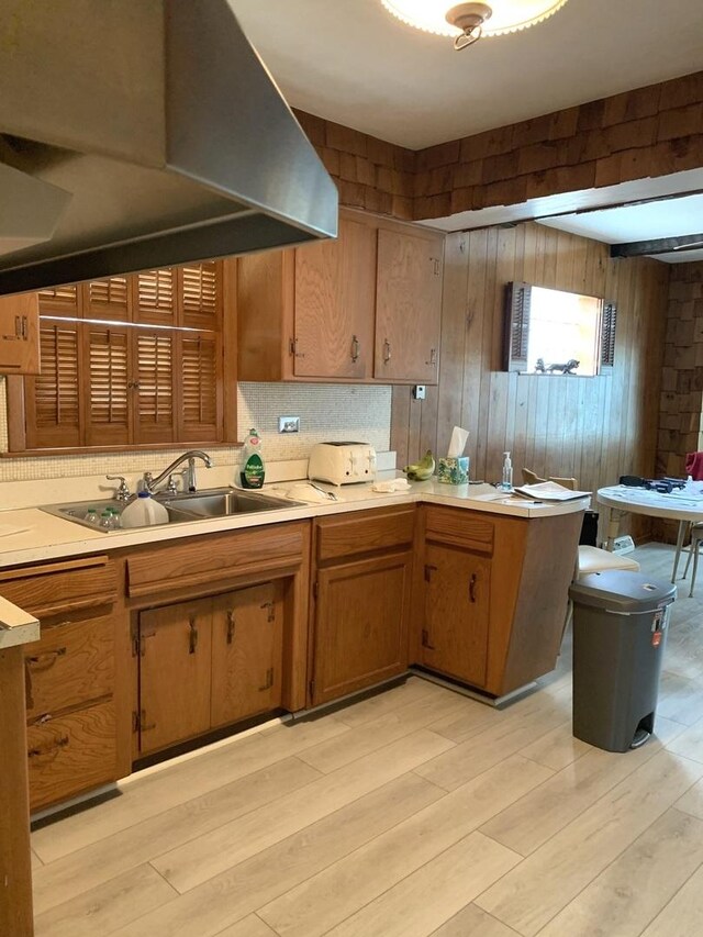 7609 W Gunnison St, Harwood Heights, IL 60706 - kitchen featuring light countertops, light wood-type flooring, ventilation hood, wood walls, and brown cabinetry