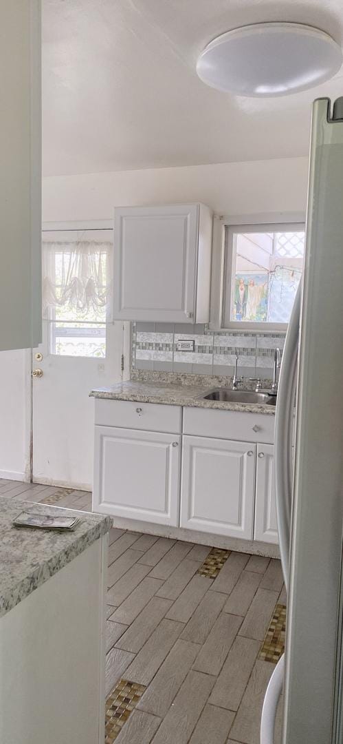 396 Thelma Ct, Wheeling, IL 60090 - kitchen with freestanding refrigerator, white cabinets, and healthy amount of natural light
