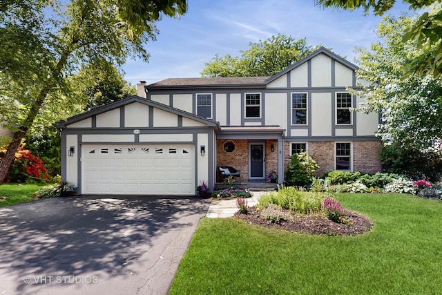 2478 Lawson Blvd, Gurnee, IL 60031 - english style home with driveway, brick siding, a front yard, a garage, and stucco siding