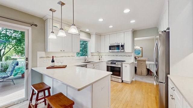 2478 Lawson Blvd, Gurnee, IL 60031 - kitchen with appliances with stainless steel finishes, a peninsula, backsplash, a breakfast bar area, and recessed lighting