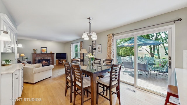 2478 Lawson Blvd, Gurnee, IL 60031 - dining space with light wood-type flooring, a brick fireplace, and a chandelier